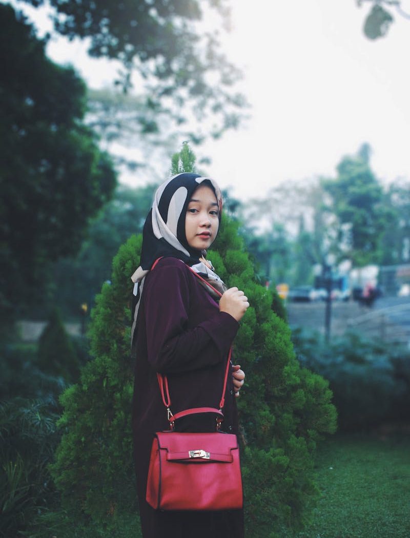 pexels-photo-1226645-1226645 Stylish young woman in hijab posing outdoors with a red handbag in Cibinong, Indonesia.